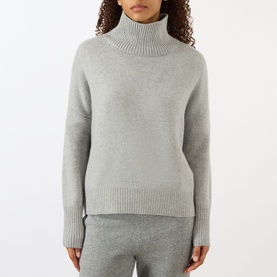 Model wearing Lisa Yang Heidi Turtleneck Cashmere Sweater in Dove Grey, styled with matching wide-leg trousers