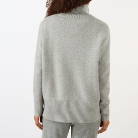 Model wearing Lisa Yang Heidi Turtleneck Cashmere Sweater in Dove Grey, back view, with ribbed trims and straight hemline