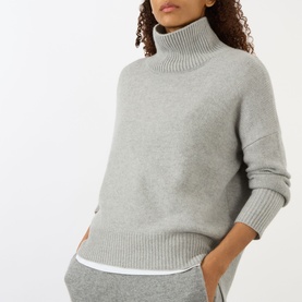 Model wearing Lisa Yang Heidi Turtleneck Cashmere Sweater in Dove Grey with ribbed trims, styled with matching grey wide-leg trousers.