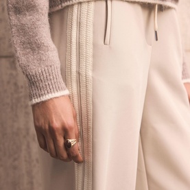 Model wearing Mint Velvet Cream Side Stripe Mid-Rise Wide Leg Trousers, styled with a grey knit top. Silver ring visible on hand.