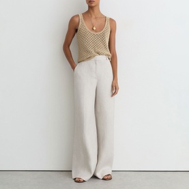 Model wearing Reiss beige wide-leg trousers with a neutral crochet tank top and gold pendant necklace.