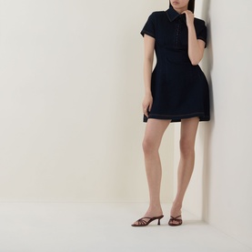 Model wearing Odd Muse dark blue short-sleeve polo mini dress, styled with tan strappy heeled mules.