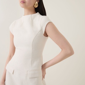 Model wearing Odd Muse Tweed Flap Pocket Mini Dress in cream, showing high round neckline, cap sleeves and fitted waist detail