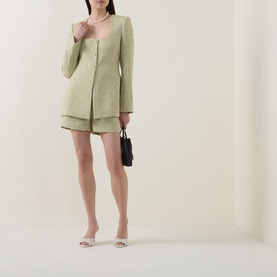 Model wearing Odd Muse green structured collarless blazer jacket with matching shorts, styled with pearl necklace, small black bag and nude heels.