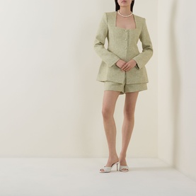 Model wearing Odd Muse green tweed shorts suit with matching blazer, pearl necklace, and white heeled mules