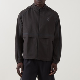 Model wearing On Running Casual Jacket in Espresso, zip-through hooded design with tonal logo, styled with black joggers.