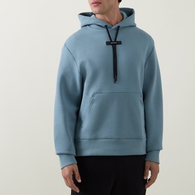 Model wearing On Running Hoodie in Agave, featuring a kangaroo pocket and black toggle drawstring detail.