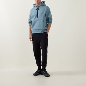 Model wearing On Running Hoodie in Agave with black joggers and black trainers, full-length shot