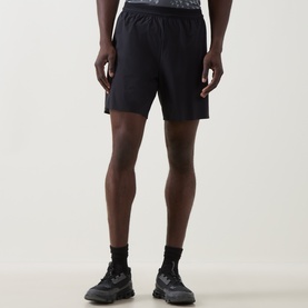 Model wearing On Running black performance shorts with elasticated waistband, styled with black socks and dark trainers