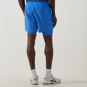 Model wearing On Running Jay Heather Shorts, back view, with white New Balance trainers and white socks visible.