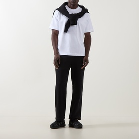 Model wearing On Running black sweatpants in cotton-polyester blend, styled with a white T-shirt and black scarf.
