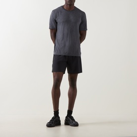 Model wearing On Running T-Shirt in Ember Heather with black shorts and black trainers.