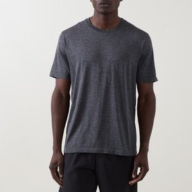 Model wearing On Running Performance T-Shirt in Ember Heather, crew neck, short sleeves, paired with black shorts.