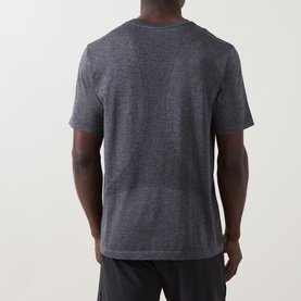 Model wearing On Running T-Shirt in Ember Heather, back view, paired with dark shorts