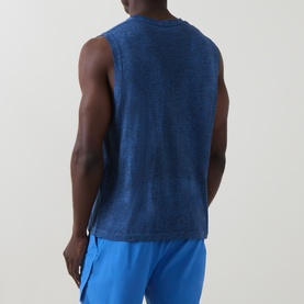 Model wearing On Running T-Shirt in Jay Heather, sleeveless cut, back view, styled with blue shorts.