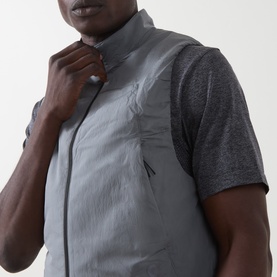 Model wearing On Running silver quilted gilet with zip fastening, styled with a grey marl short-sleeve top