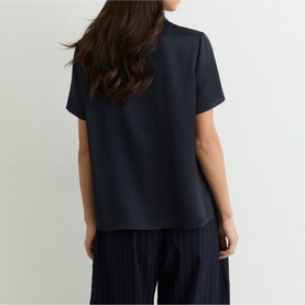 Model wearing Reiss blue short-sleeve top, rear view, styled with navy striped wide-leg trousers