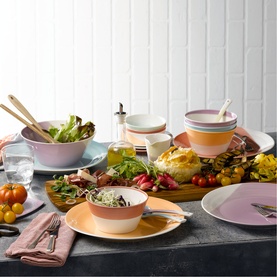 Royal Doulton multi-coloured dinnerware set styled on a dining table with salad bowl, plates, and side dishes in pastel tones