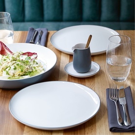 Royal Doulton white dinner set styled on a wooden table, including plates, bowl with salad, small jug, and glassware.