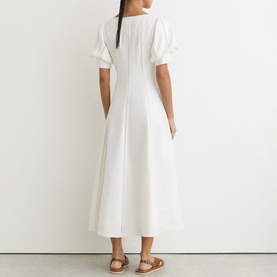 Model wearing Reiss white midi dress with puff sleeves and fitted bodice, shown from back, styled with tan sandals