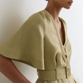 Model wearing Reiss green dress with V-neckline, batwing sleeves, button front, and matching belt at waist