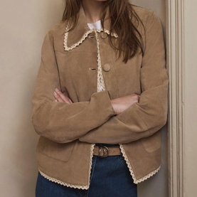 Model wearing camel suede-effect jacket with cream lace trim collar and cuffs, styled with white top and blue jeans