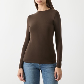 Model wearing Selected Femme knit top in Delicioso brown, long-sleeved with crew neck, styled with light blue jeans.