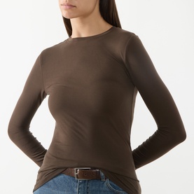 Model wearing Selected Femme Delicioso brown long-sleeve fitted top with crew neck, styled with blue jeans and brown belt.