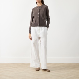 Model wearing Selected Femme Delicioso wool cardigan with white wide-leg trousers and taupe flat shoes.