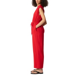 Model wearing Whistles red sleeveless wide-leg jumpsuit with tie waist detail, styled with black flip-flop sandals