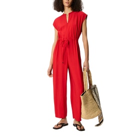 Model wearing Whistles red wide-leg drawstring jumpsuit with cap sleeves, styled with a woven tote bag and black sandals.