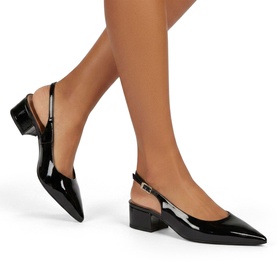 Model wearing Carvela black patent leather pointed-toe slingback heels with low block heel and ankle strap buckle fastening.