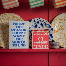 Archivist gift box set displayed on red shelf with decorative plates, featuring typographic "Perfect Match" and "You're The Reason" designs