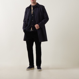 Model wearing Barbour Navy cardigan layered under a navy overcoat, styled with black trousers and dark trainers.