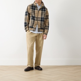 Model wearing Barbour Birchwood Dress Tartan casual jacket, styled with light blue shirt, beige trousers and dark brown loafers.