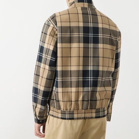 Model wearing Barbour casual jacket in Birchwood Dress Tartan, back view, styled with beige chinos.