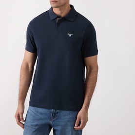 Model wearing Barbour navy cotton polo shirt with short sleeves and contrast collar, styled with blue jeans