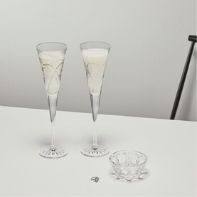 Waterford clear crystal champagne flutes, pair, with etched detailing, styled with a small crystal bowl and ring on a white surface