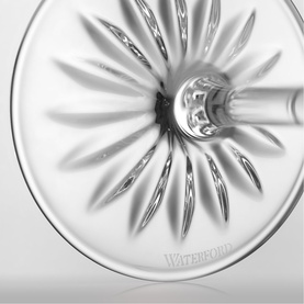 Waterford clear crystal glassware close-up showing intricate sunburst cut pattern on base, with brand etching visible