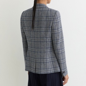 Model wearing Reiss navy check blazer, shown from behind, with tailored fit and long sleeves, styled with navy wide-leg trousers.