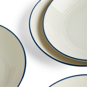 Gordon Ramsay blue and cream ceramic dinner plates with navy rim detail, shown stacked at an angle on white background