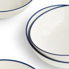 Gordon Ramsay blue and white ceramic bowls with navy blue rim detail, set of four shown at angle on white surface