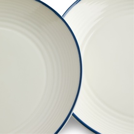 Gordon Ramsay ceramic plates in cream with blue rim detail, showing ridged texture on two stacked round plates.