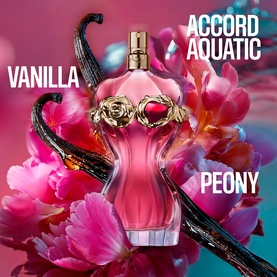 Jean Paul Gaultier La Belle Rosea Eau de Parfum bottle with gold rose cap, surrounded by peonies and vanilla pods