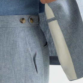 Reiss soft blue linen-blend suit trousers and blazer, close-up detail showing button fastening and cream contrast lining