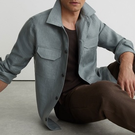 Model wearing Reiss midnight green overshirt with chest pockets, styled with brown trousers and black T-shirt
