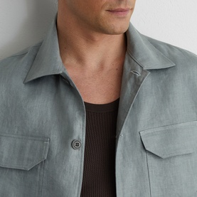Model wearing Reiss midnight green overshirt with chest pockets and button placket, styled over a dark ribbed knit top.