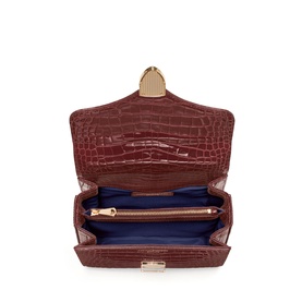 Aspinal of London merlot croc-embossed mini bag, open view showing blue interior compartments and gold-tone hardware clasp.