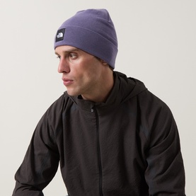 Model with North Face Dock Worker Logo Beanie Hat in Grounded Plum, ribbed turn-up design with logo badge, styled with black jacket.