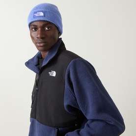 Model with North Face Logo Box Beanie Hat in Indigo Wonder, ribbed knit with turn-up cuff, styled with navy and black fleece jacket.